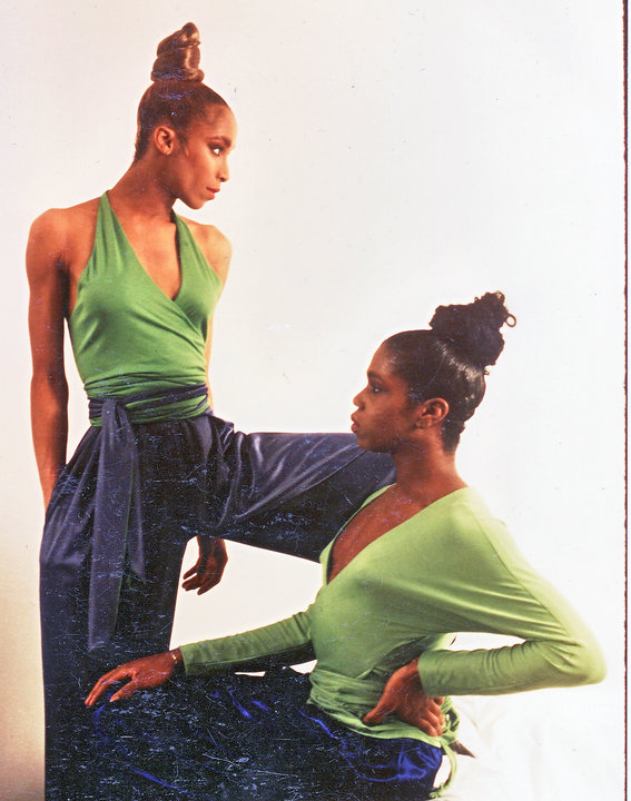 Two models wearing green tops and satiny blue wide loose pants