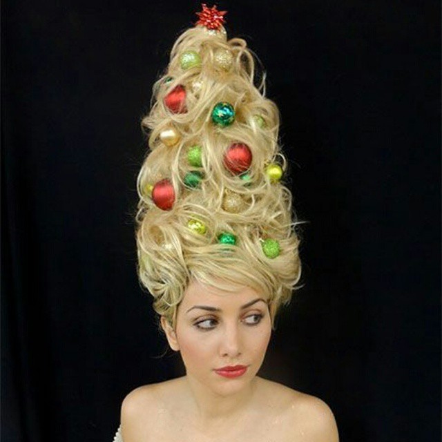 Woman with tall, blonde, cone shaped hair with Christmas ornaments