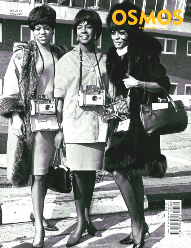 Black and white photo of 3 women standing with cameras