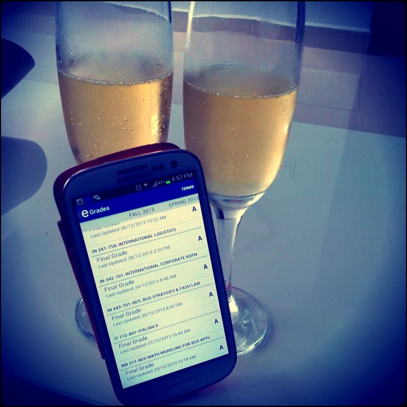 two champagne glasses and cellphone with grades