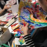 close up of hands cutting a colorful painting