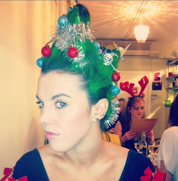 Woman with spiky green dyed hair with Christmas ornaments 