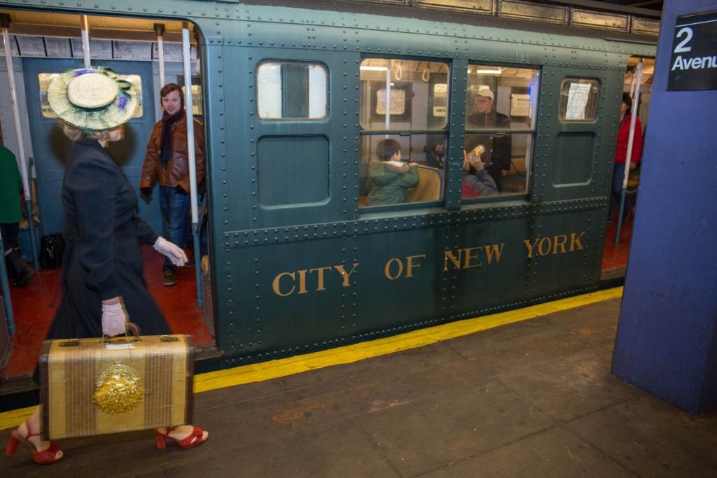 Woman walking past vintage NYC subway car